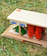 Beck wooden toy car wash with two toy cars placed inside.