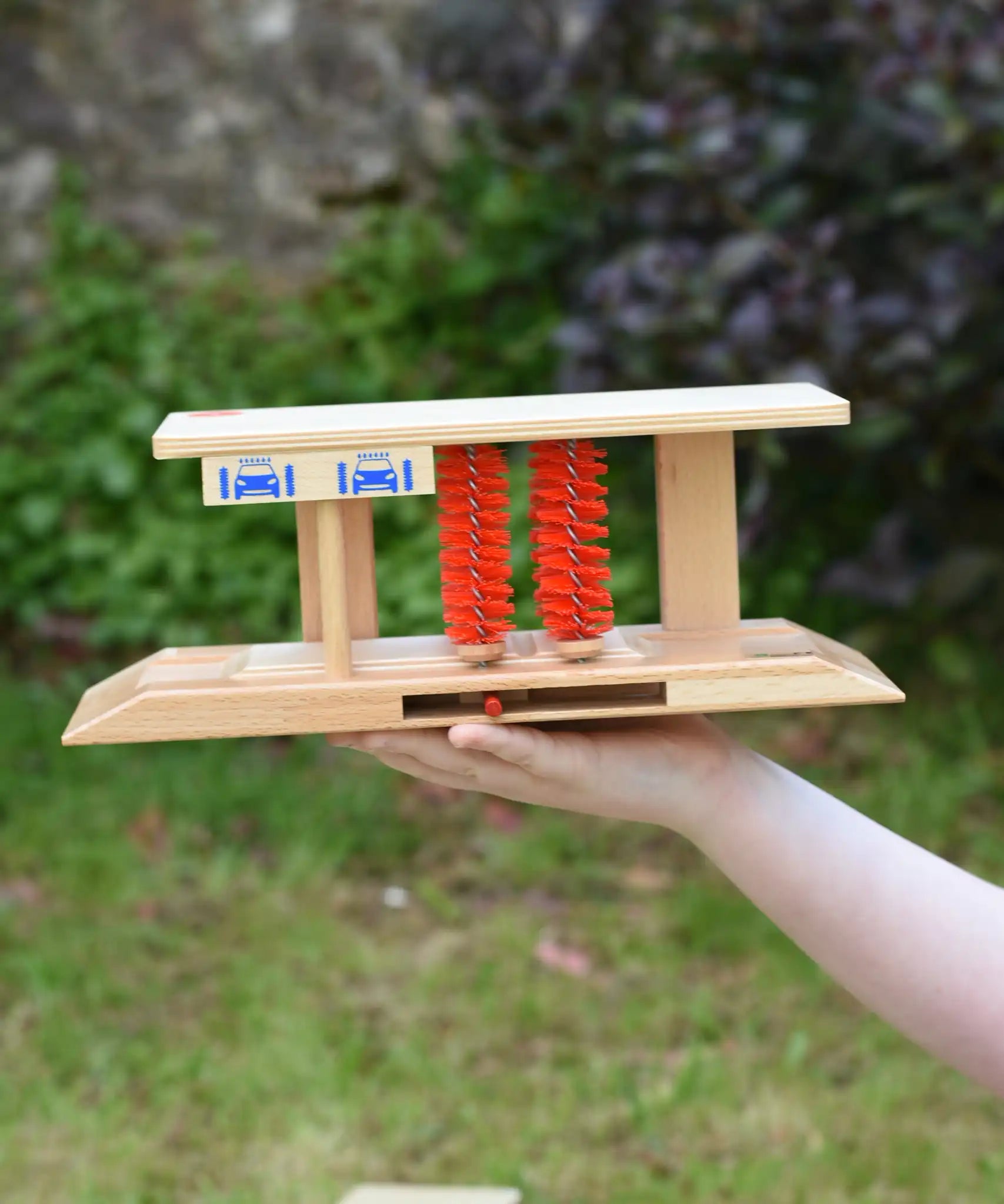 Beck wooden toy car wash in a child's hand.