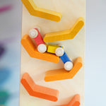 A close up of the millipede car train on the Beck Toys Beechwood Cascading Tower Running Track. Motion blue can be seen on the wooden car train as it races down the track.