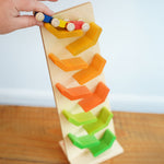 The wooden millipede car train being placed on the Beck Toys Beechwood Cascading Tower Running Track.