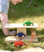 Beck wooden garage & petrol station with toy card placed on the ramp and on the roof.