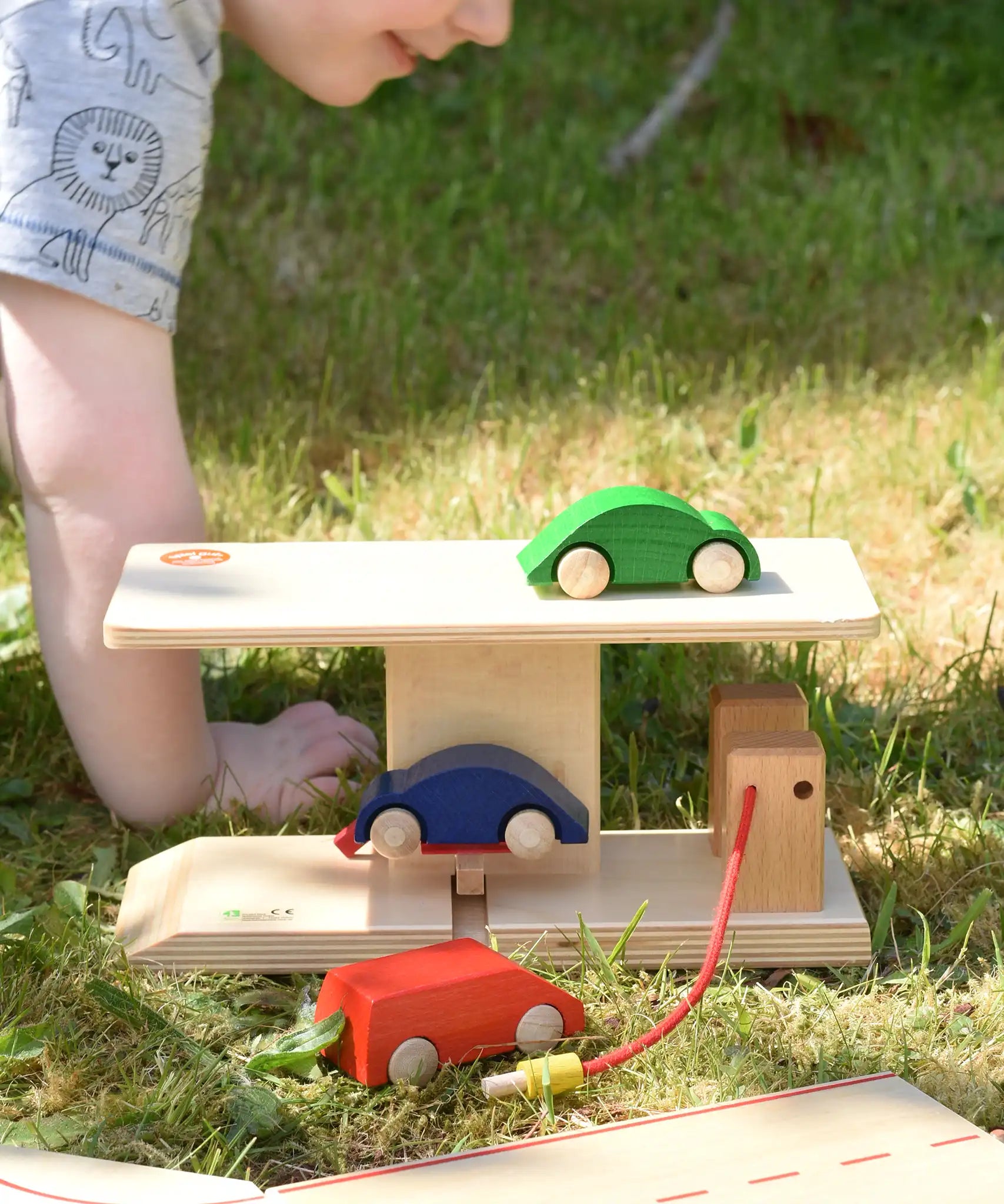 Beck wooden garage & petrol station with toy card placed on the ramp and on the roof.