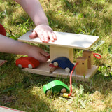 Child lifting the ramp on the Beck wooden garage & petrol station using the red handle.