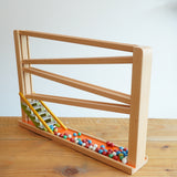 Beck Toys Chimes Marble Run Track placed on a wooden surface. The set comes with 50+ small coloured clay marbles.
