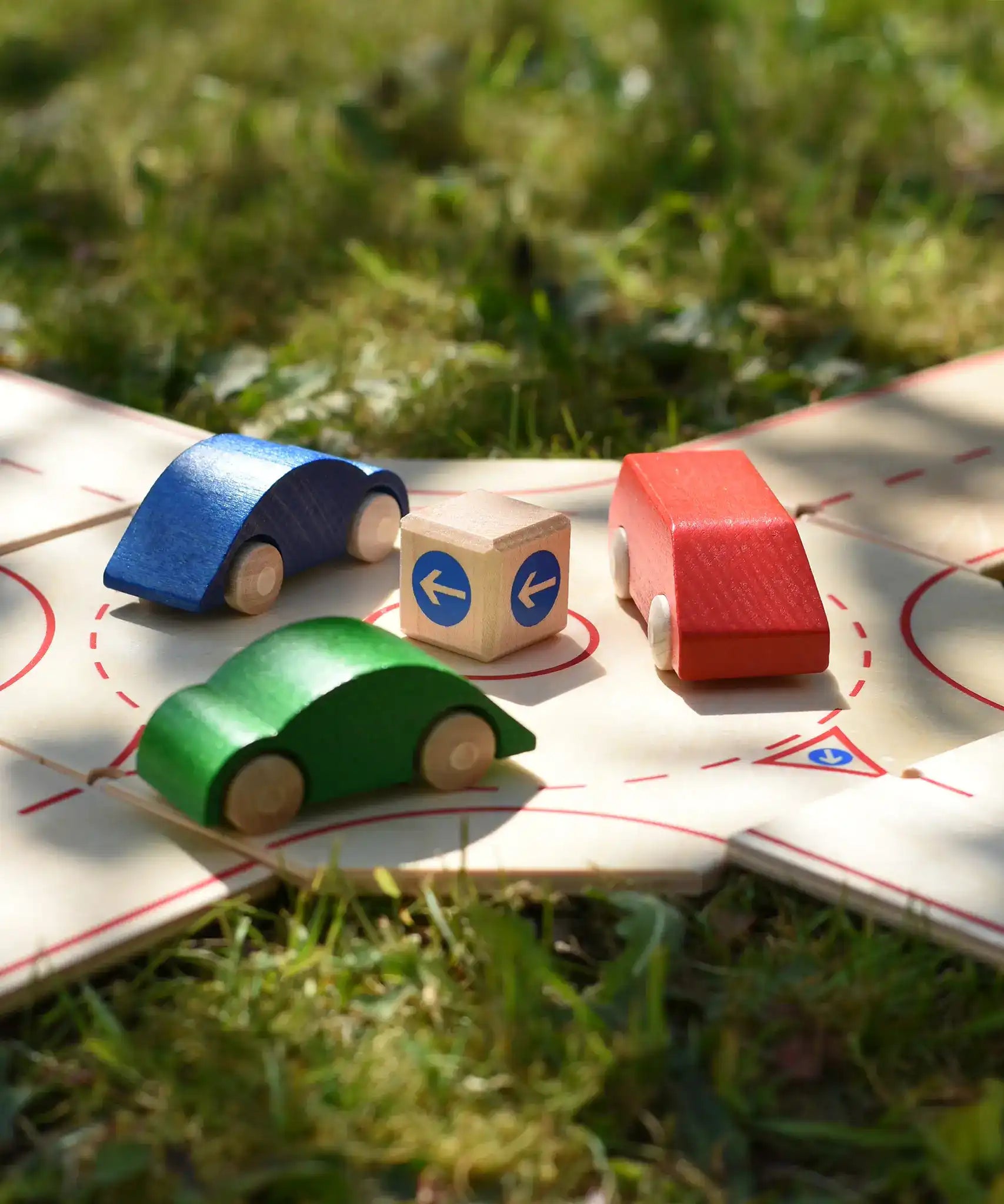 Close up of the Beck wooden roundabout junction set with toy cars placed on the roundabout.