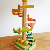 A Beck Toys Beechwood Step Tower with Glockenspiel Chimes placed on a wooden surface.