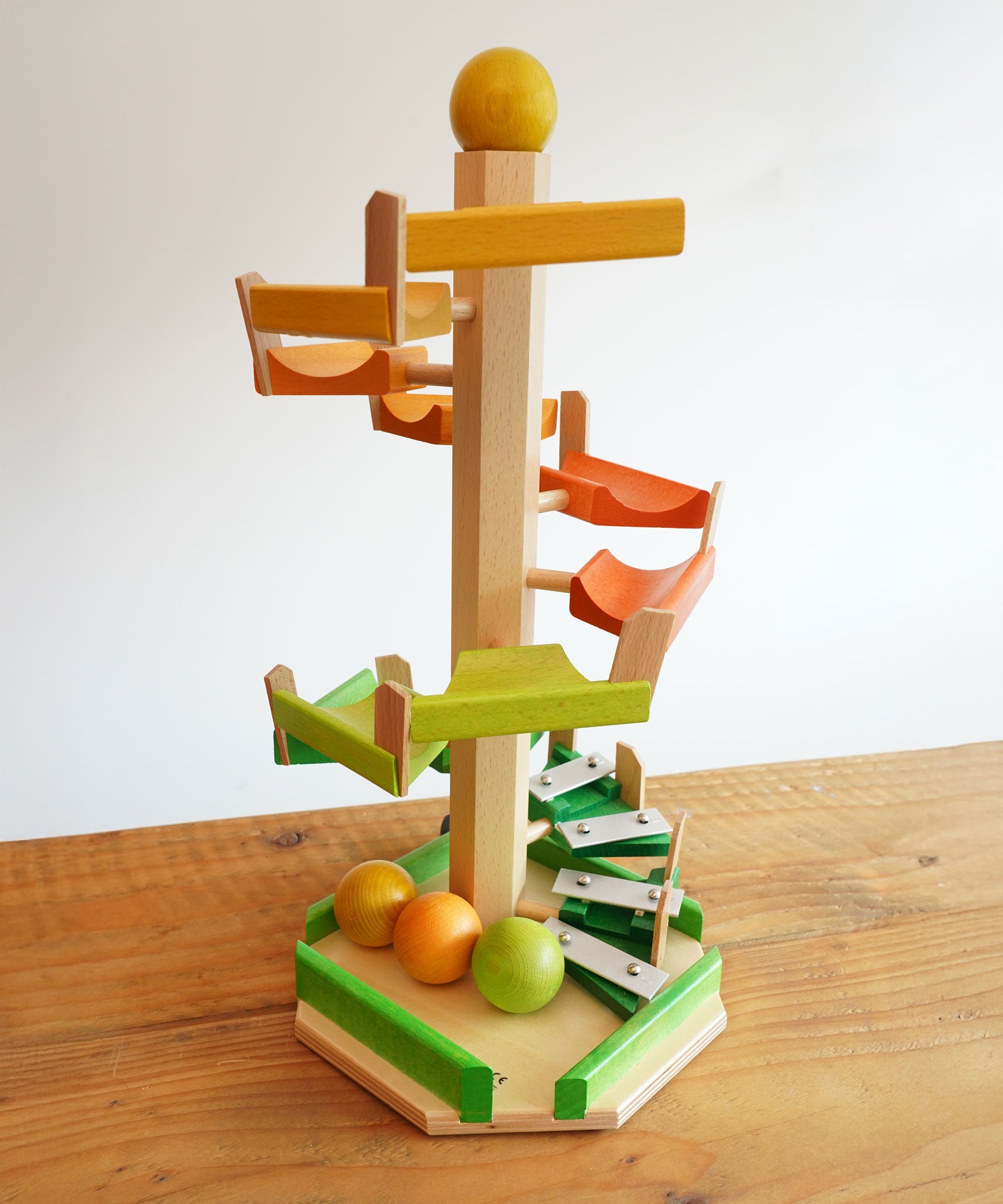 A Beck Toys Beechwood Step Tower with Glockenspiel Chimes placed on a wooden surface.