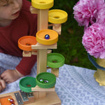 A child observing the glass marbles twirling down the Beck Toys Beech Wood Plate Tower Marble Run with Glockenspiel. 