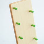 A close up of the small, green coloured, wooden rungs on the Beck wooden Toys Wobbler with Red Person Figure Set. 