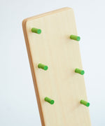 A close up of the small, green coloured, wooden rungs on the Beck wooden Toys Wobbler with Red Person Figure Set. 
