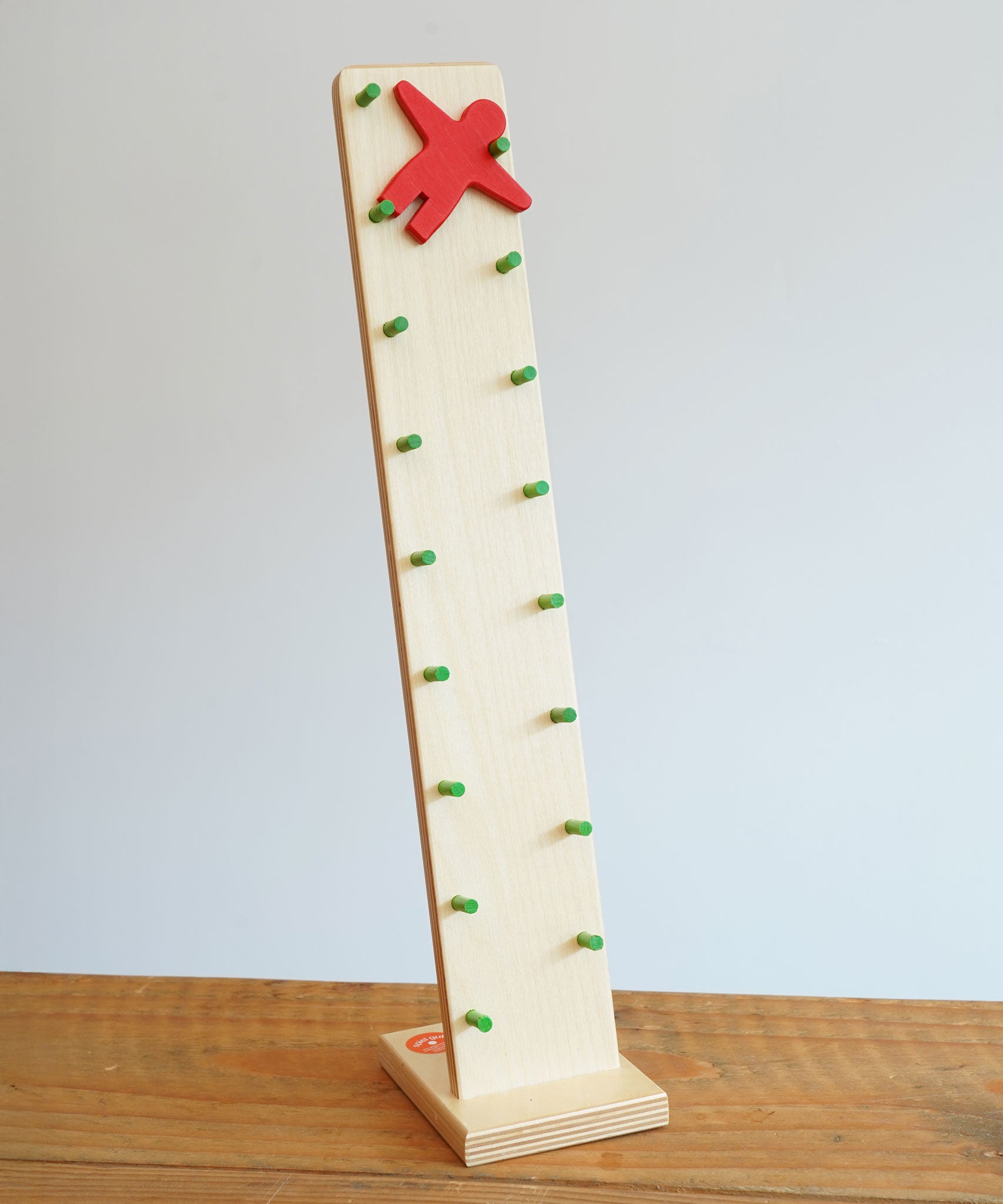 Beck wooden Toys Wobbler with Red Person Figure placed on a wooden surface. 