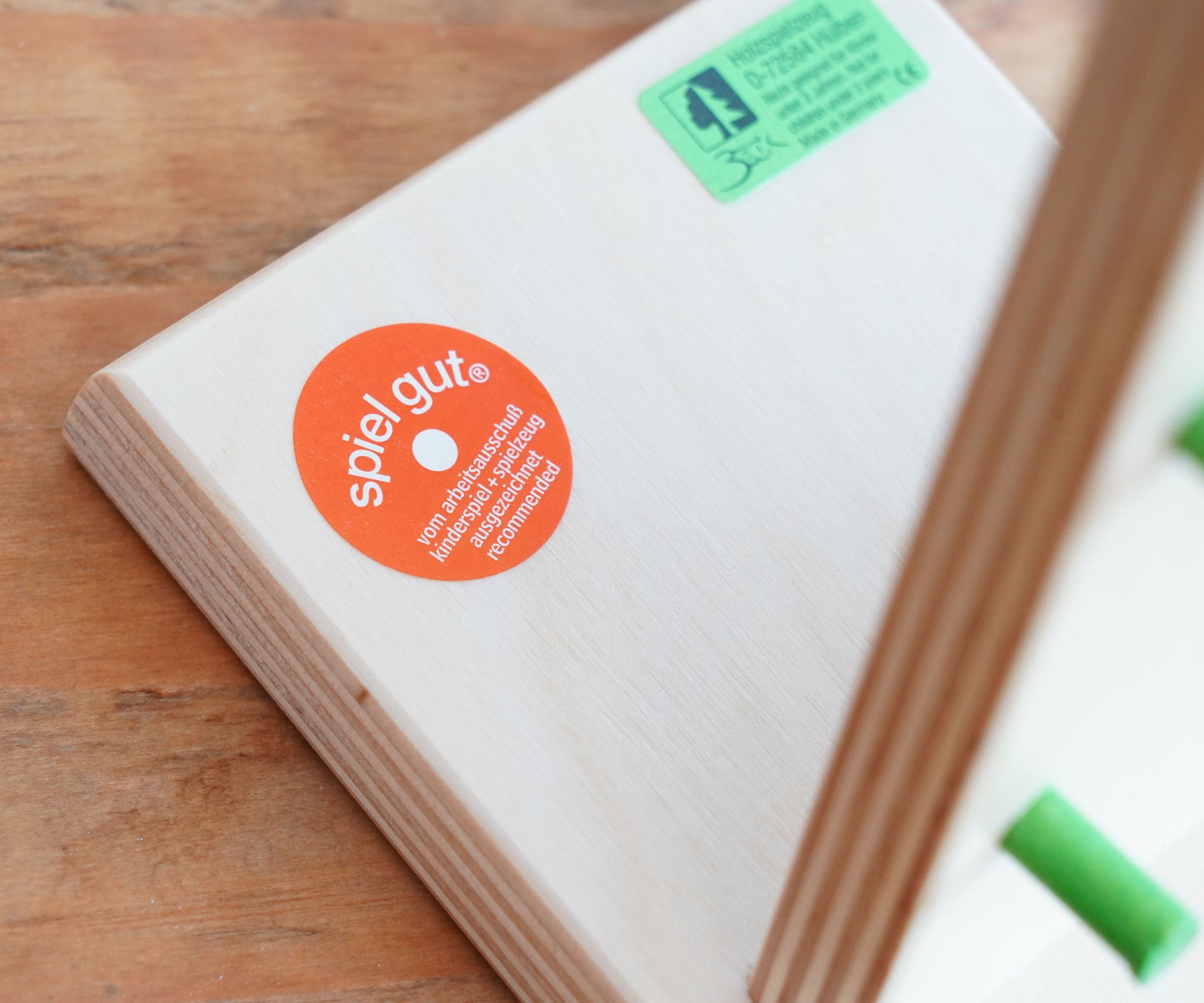 A close up of the Spiel Gut certification sticker on the Beck wooden Toys Wobbler Toy.