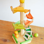 The Beck Toys Beechwood Step Tower with Glockenspiel Chimes placed on a wooden surface. The set comes with the coloured wooden balls.