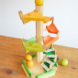 The Beck Toys Beechwood Step Tower with Glockenspiel Chimes placed on a wooden surface. The set comes with the coloured wooden balls.