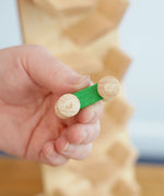 A close up of teh green car from teh Beck Toys Beechwood Cascading ‘Tower Running Track’ with Race Cars set in an adult's hand. 
