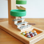 A close up of the glass marbles placed on the base of the Beck Toys Beech Wood Marble Run ‘Plate Tower’ with Glockenspiel.