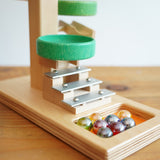 A close up of the glass marbles placed on the base of the Beck Toys Beech Wood Marble Run ‘Plate Tower’ with Glockenspiel.