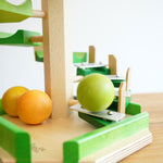 A close up of a wooden ball cascading down the Glockenspiel on the Beck Toys Beechwood Step Tower.