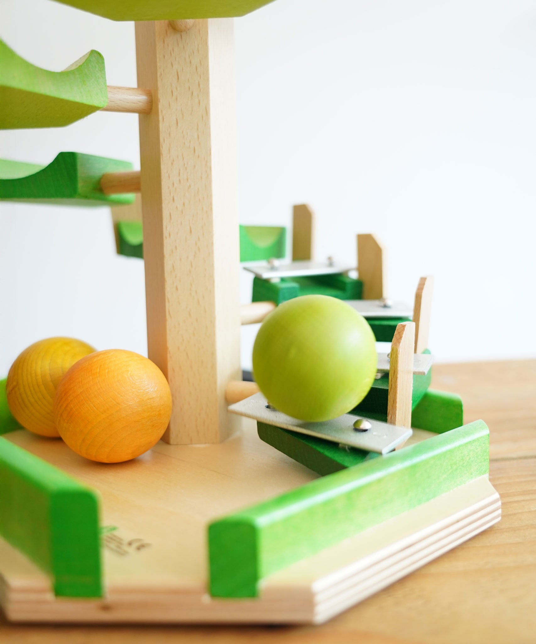 A close up of a wooden ball cascading down the Glockenspiel on the Beck Toys Beechwood Step Tower.