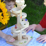 Two children playing with the Beck Marble Run Plate Tower outdoors.