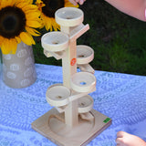 A child about to place glass marbles on the Beck Marble Run Plate Tower.