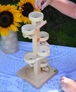 A child about to place glass marbles on the Beck Marble Run Plate Tower.