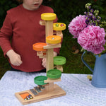 A child observing the glass marbles twirling down the Beck Toys Beech Wood Plate Tower Marble Run with Glockenspiel. 