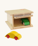 Beck Holzspielzeug Wooden Small Toy Car Garage shown with door open and one car inside and one outside. This wooden toy car garage is part of a wide range of toy vehicles and accessories available at Babipur.
