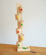 The Beck Toys Beech Wood Roller Cup Marble Run placed on a wooden surface.