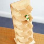 An overhead view of a green coloured wooden racing car racing down the Beck Toys beechwood cascading tower track.