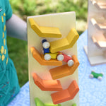 A close up of the car train from the Beck Toys Beechwood Cascading ‘Tower Running Track’ with Millipede Car Train set blurred in motion as it races down the track. 