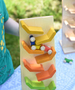 A close up of the car train from the Beck Toys Beechwood Cascading ‘Tower Running Track’ with Millipede Car Train set blurred in motion as it races down the track. 