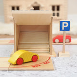 Beck wooden toy car driving towards a twin garage with a parking sign standing near
