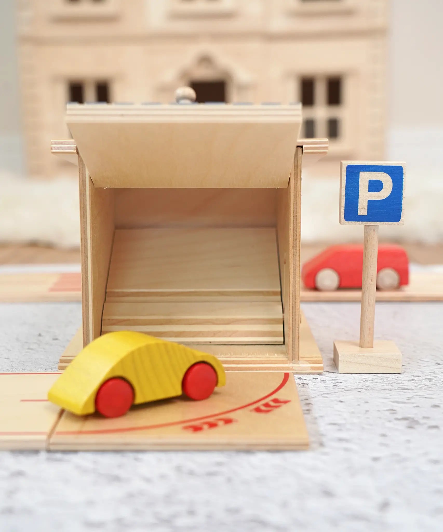Beck wooden toy car driving towards a twin garage with a parking sign standing near