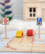 A Beck wooden speed limit and parking sign standing near a road set with vehicles on top 