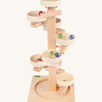Beck Toys wooden tower marble run. Made from beech wood showing a series of plates along the stand and marbles travelling down