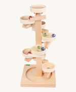 Beck Toys wooden tower marble run. Made from beech wood showing a series of plates along the stand and marbles travelling down