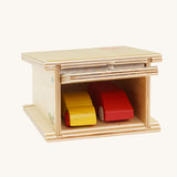 A Beck Holzspielzeug Wooden Small Toy Car Garage with two wooden cars inside. This wooden toy car garage is part of a wide range of toy vehicles and accessories available at Babipur.