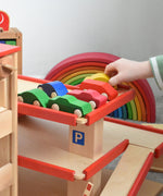 A collection of Beck wooden vehicle toys parked on the top level of the multi-storey car park. Beck have a range of wooden toys and ball runs available at Babipur. 
