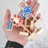 An adult hand with a bunch of Beck wooden traffic showing scale