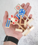 An adult hand with a bunch of Beck wooden traffic showing scale
