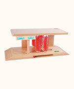 Beck wooden car wash toy showing a ramp on each end with red bristles in the middle and a handle to move the bristles