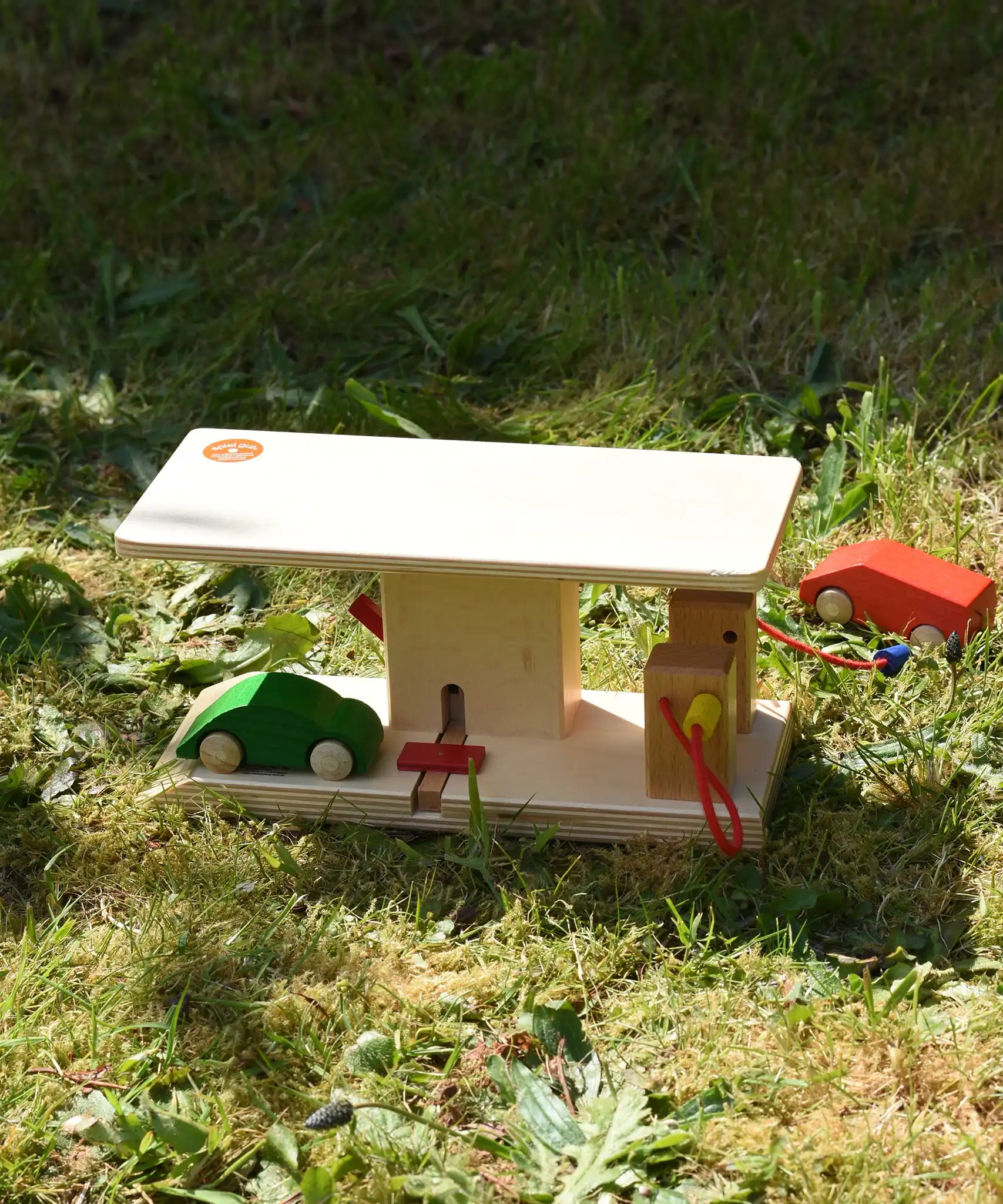 Beck wooden garage & petrol station with wooden toy cars and van placed around it in a simple small world play set up.