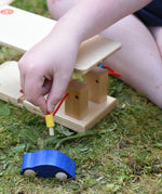 fueling hose from the Beck wooden garage & petrol station in a child's hand.