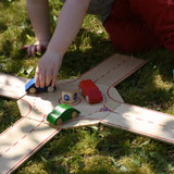 Beck wooden roundabout junction set, child placing toy cars on the roundabout. 