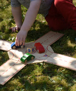 Beck wooden roundabout junction set, child placing toy cars on the roundabout. 