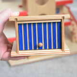 A Beck wooden toy car garage shown in an adult's hand. This wooden toy car garage is part of a wide range of toy vehicles and accessories available at Babipur.