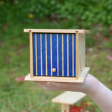 Beck wooden double garage toy in a child's hand. The blue door is closed.