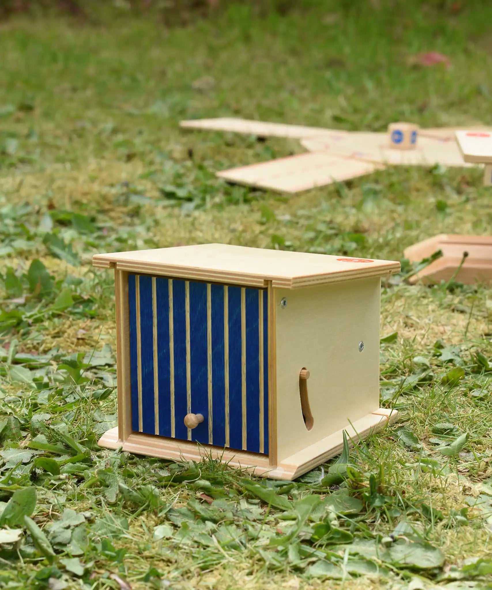 Beck wooden double garage toy placed on grass outdoors.
