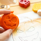 Close up of hand colouring in a pumpkin drawing with the bee crayative large pumpkin coloured crayon